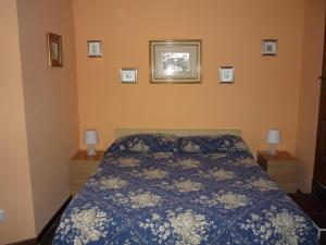 1 dormitorio con 1 cama con edredón azul en Affittacamere Andronaco, en Milán