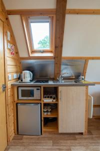 a kitchen in a tiny house with a sink and a window at Chawton Park Farm by Wigwam Holidays in Chawton