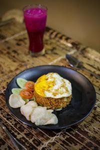 a plate with an egg and vegetables on a table at Senaru Gateway homestay in Senaru