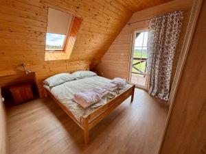 a bedroom with a bed in a wooden cabin at U Marcjana in Kamienica Królewska