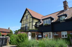 a yellow and black house with a black roof at The Dolphin Inn in Thorpeness