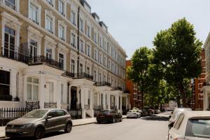 a street with cars parked in front of buildings at Kensington Prime Apartments in London
