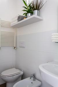 Un baño blanco con inodoro y lavabo. en Cuore Flat, en Módica