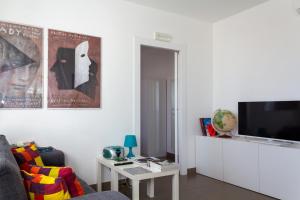 Una sala de estar con un sofá y un televisor de pantalla plana. en Cuore Flat, en Módica