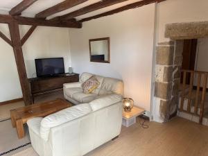 a living room with a white couch and a tv at Countryside Gîte in Asnois
