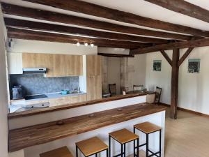 a kitchen with wooden counters and stools in a room at Countryside Gîte in Asnois