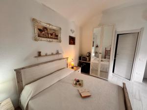 a bedroom with a large white bed with a mirror at Stanza Angeli in Nulvi