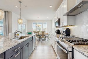a kitchen with white cabinets and a dining room at Oyster House Village --- 21503 Helm St in Rehoboth Beach