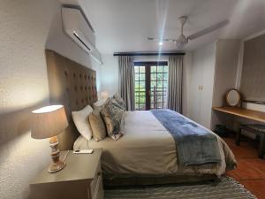 a bedroom with a bed and a table with a lamp at Golf Estate Vacation Property - Poseidon's Knoll in White River +53 photos