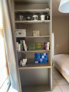 ein Bücherregal in einem Schlafzimmer mit Büchern in der Unterkunft Chez Eloi in Tacfesse