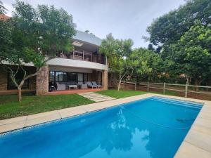 a house with a swimming pool in front of a house at Golf Estate Vacation Property - Poseidon's Knoll in White River