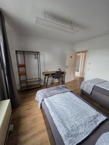 a bedroom with two beds and a table and a desk at Schwarzwald Lodge OG - Perfekt für Familien und Gruppen in Calw