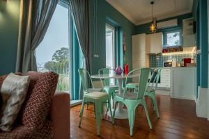 a kitchen with green walls and a table and chairs at Douro Prestige Urban Retreat with shared S-Pool & Gym in Porto