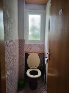 a small bathroom with a toilet and a window at Double Bedroom with Balcony in Lenzburg