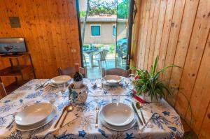 a table with plates and a bottle of wine on it at Villaggio California in Eraclea Mare