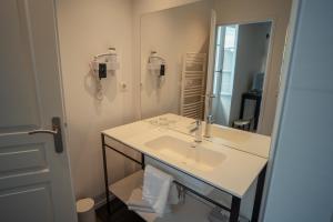 a white bathroom with a sink and a mirror at Maison d'hôtes PACHAMAMA in Ahetze +28 photos