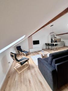 a living room with a couch and a table at Spacieux 2 chambres in Oyonnax +6 photos