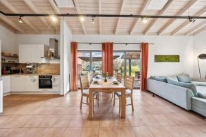 eine Küche und ein Wohnzimmer mit einem Tisch und einer Couch in der Unterkunft PINTO ROSSO - rotes Strandhaus an idyllischem Privatsee in Twist