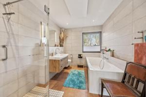 ein Badezimmer mit Badewanne und Waschbecken in der Unterkunft PINTO ROSSO - rotes Strandhaus an idyllischem Privatsee in Twist