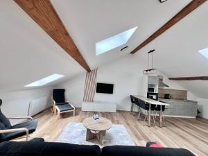 a living room with a couch and a table at Spacieux 2 chambres in Oyonnax
