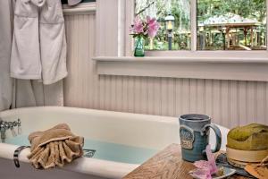 une salle de bain avec une baignoire et une tasse à café sur une table dans l'établissement Magnolia Plantation & Cottages, à Gainesville