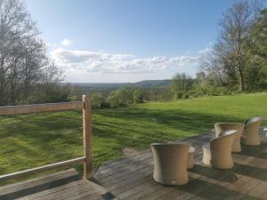 a deck with chairs and a view of a field at les marronniers in Cambremer