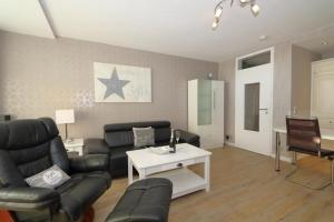 a living room with a couch and a table at Haus Käptn Christiansen 46 in Westerland +14 photos