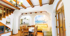 a living room with a table and a yellow couch at Pensiunea Roșu Litoral in Douăzeci şi Trei August