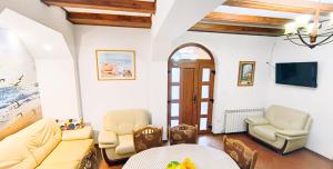a living room with a couch and chairs and a table at Pensiunea Roșu Litoral in Douăzeci şi Trei August