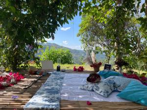 Una cama sentada sobre una mesa debajo de un árbol. en Private cabin with mountains view, en Estación El Salto