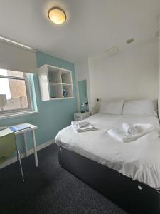 a bedroom with a bed with towels on it at Budget En-suite Room in Coventry City Centre in Coventry