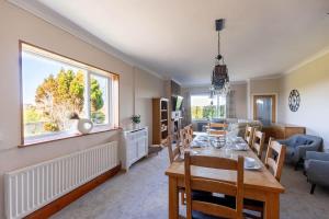a dining room and living room with a table and a window at Spacious 4-Bed Lake District Getaway for Groups in Mealsgate