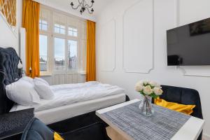 a bedroom with a bed and a table with a vase of flowers at Loggia Apartments in Poznań