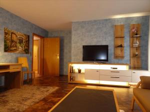 una sala de estar con TV en un armario blanco en Ferienwohnung Mühlengrün, en Oberwolfach 19 fotos más