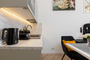 a kitchen with a table with a coffee pot on a counter at Loggia Apartments in Poznań