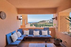un divano blu su un balcone con vista sull'oceano di Ocean view apartment en la duquesa golf - COTO REAL 321 a Manilva
