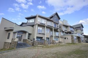 a large house with a stone driveway at 2 Bedroom Ski In Ski Out at Mount Hotham in Mount Hotham