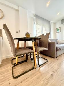 una mesa y sillas en una sala de estar con sofá en Be Happy, Santa Pola Apartamento a 50 metros de la Gran Playa, en Santa Pola