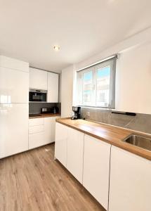 Una cocina con gabinetes blancos y un fregadero y una ventana. en Be Happy, Santa Pola Apartamento a 50 metros de la Gran Playa, en Santa Pola 25 fotos más