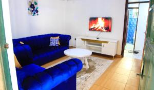 a living room with a blue couch and a table at D&A Homes in Eldoret