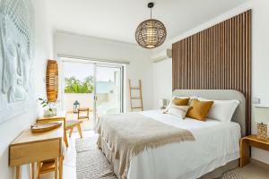 a bedroom with a bed and a desk and a window at Casa Eleonora lifestyle Lodge in Lagos +18 photos