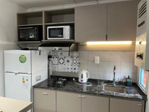 a kitchen with a white refrigerator and a sink at Dilans in San Luis