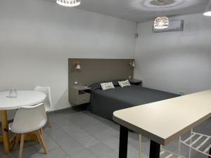 a bedroom with a bed and a table and a table and chairs at Dilans in San Luis