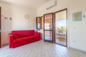拉契亚AffittaSardegna - Trilo li Frati的客厅里一张红色的沙发,配有滑动玻璃门