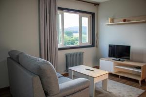 Val do DubraにあるApartamento Centro Bembibreのソファとテレビのあるリビングルーム