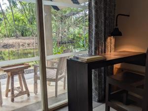 einen Schreibtisch und ein Fenster mit einem Tisch und einem Stuhl in der Unterkunft The Acadian Cottages in Madampe