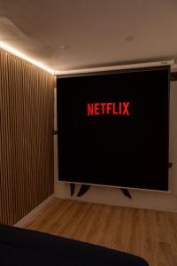 telewizor z napisem netflix na ścianie w obiekcie Appartement jungle w mieście Moulins