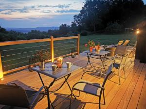 a wooden deck with tables and chairs on it at les marronniers in Cambremer +30 photos