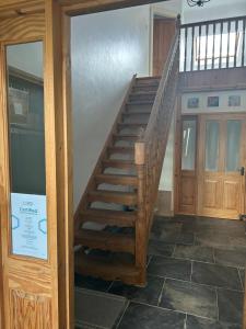 a wooden staircase in a room with a door at Lyza's Loft in Kilcoo