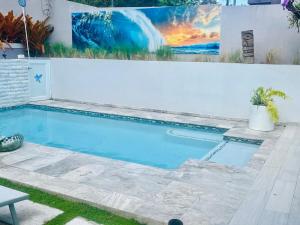 a swimming pool in front of a white fence at Under Sea Guest House in Toa Alta +61 photos